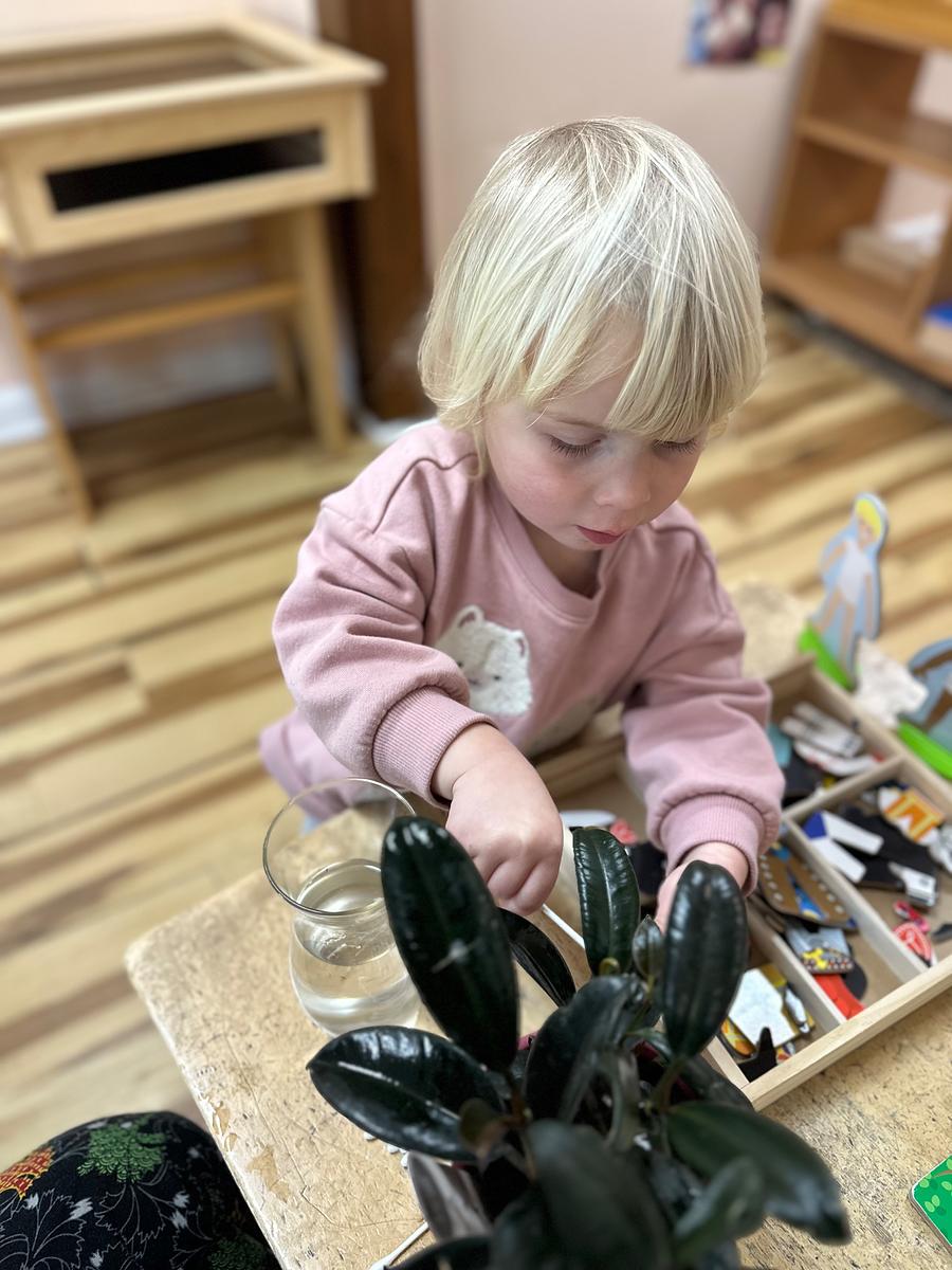 A young child playing with a toy lobster indoors.