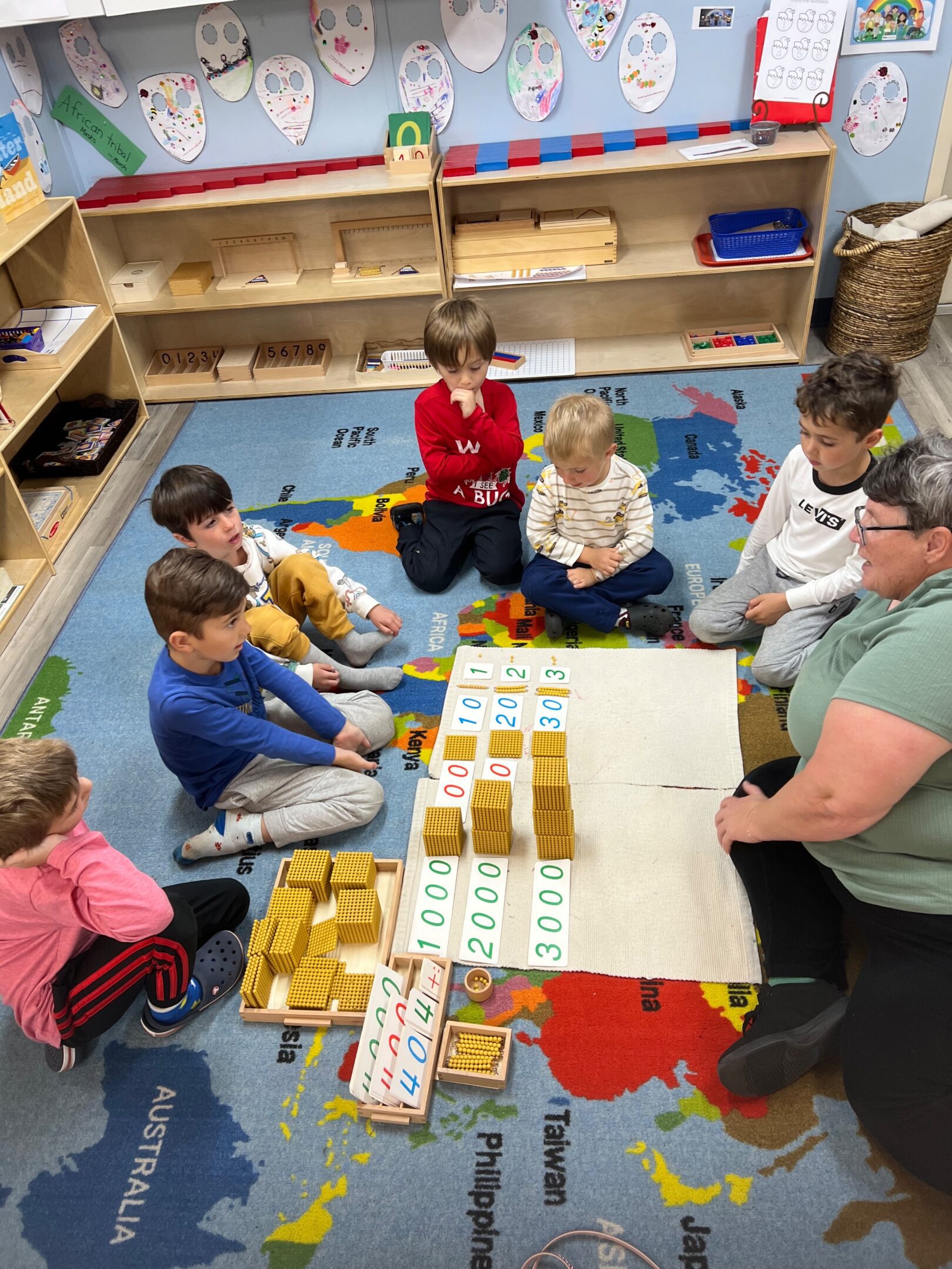 Children and teacher engaged in a hands-on learning activity with educational materials.
